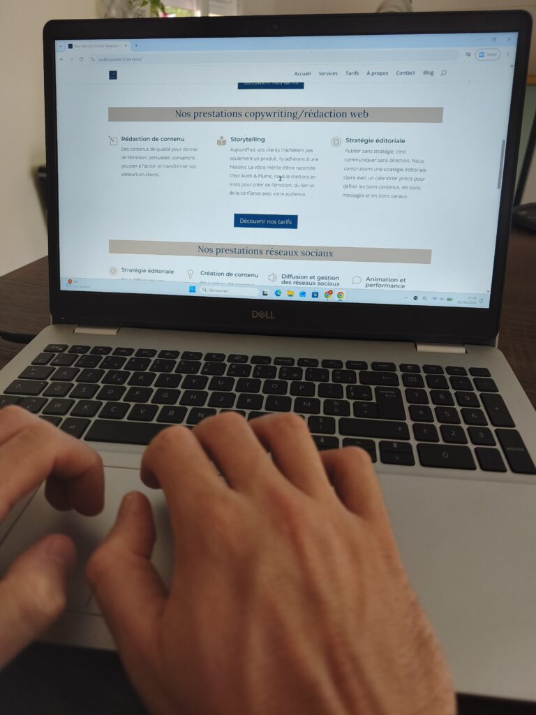 Mains tapant sur le clavier d'un ordinateur affichant les services de copywriting d'Audit et Plume.